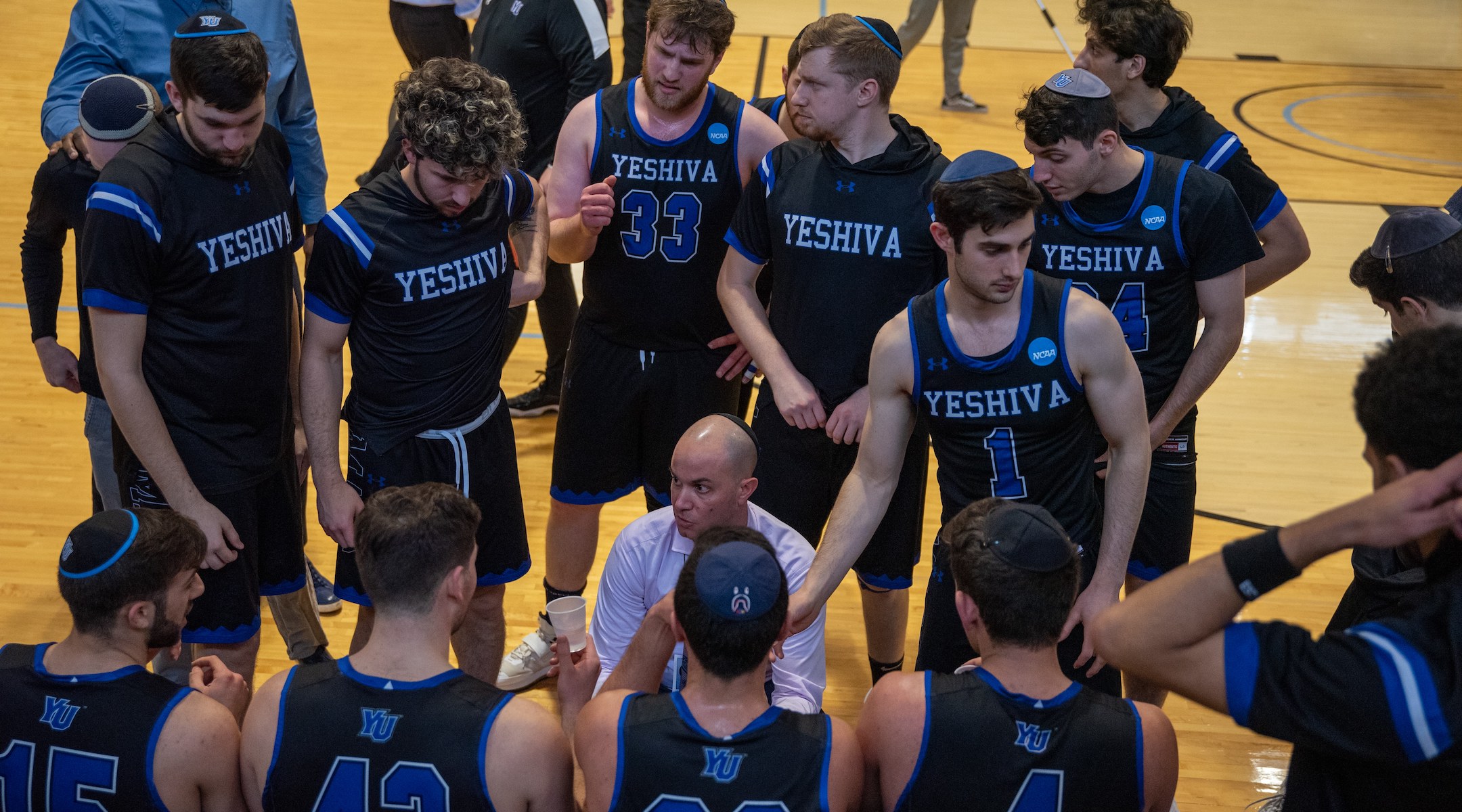 Coach Elliot Steinmetz instructs his Yeshiva University’s men’s basketball team. (YU Athletics)