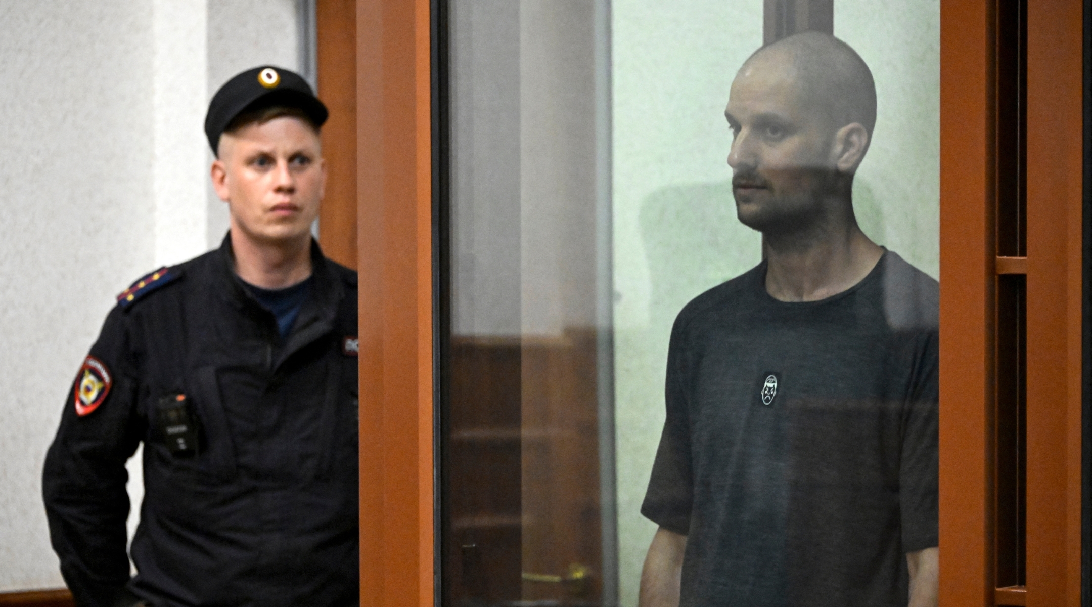 American journalist Evan Gershkovich stands in a glass defendant’s cage during the verdict announcement at the Sverdlovsk Regional Court in Yekaterinburg on July 19, 2024. (Alexander Nemenov/AFP via Getty Images)