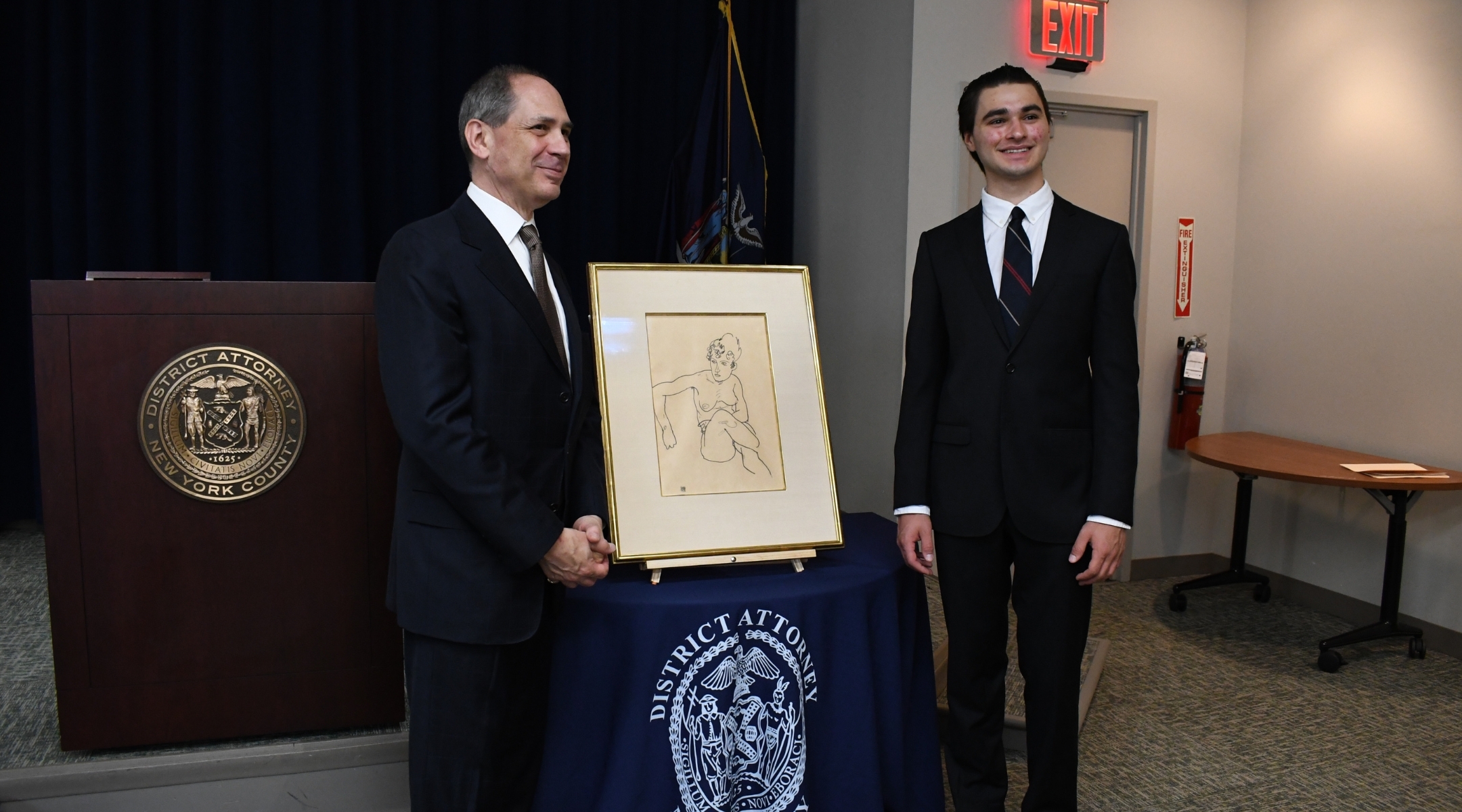 Timothy Reif and son Paul Reif pose in front of “Seated Nude Woman, front view,” an Egon Schiele drawing stolen by the Nazis from the private collection of their ancestor, Fritz Grünbaum. (Jackie Hajdenberg)