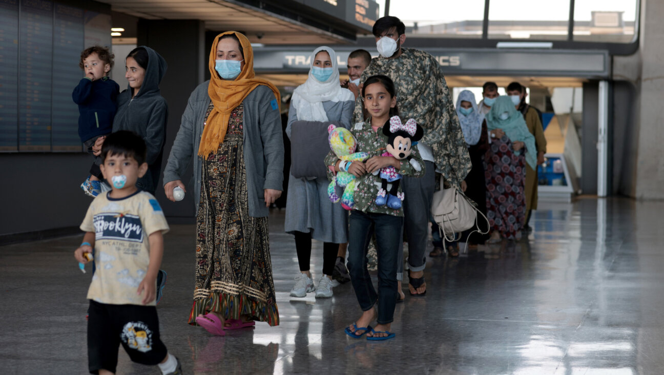 A family evacuated from Afghanistan is led through the arrival terminal at Dulles International Airport in the Washington area to board a bus that will take them to a refugee processing center, Aug. 25, 2021. (Anna Moneymaker/Getty Images)