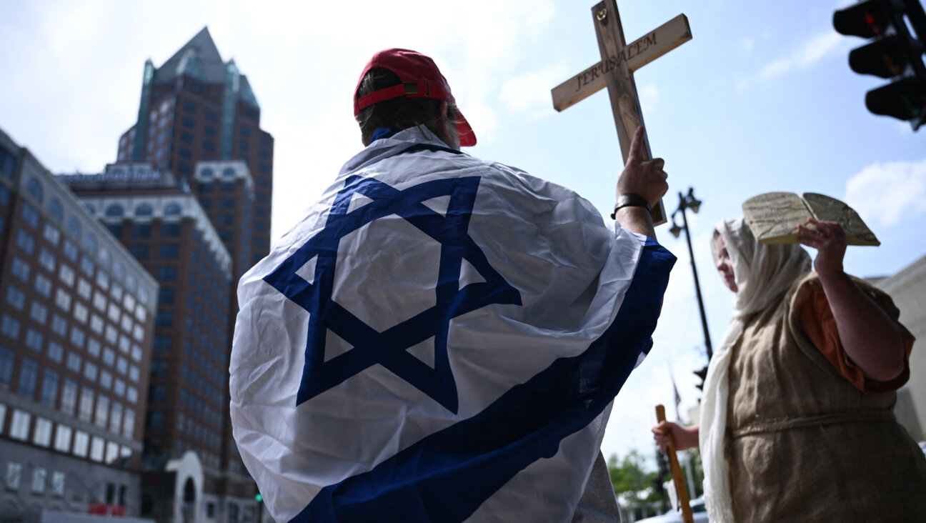 Outside the RNC, a Christian woman wears an Israeli flag while holding a cross.