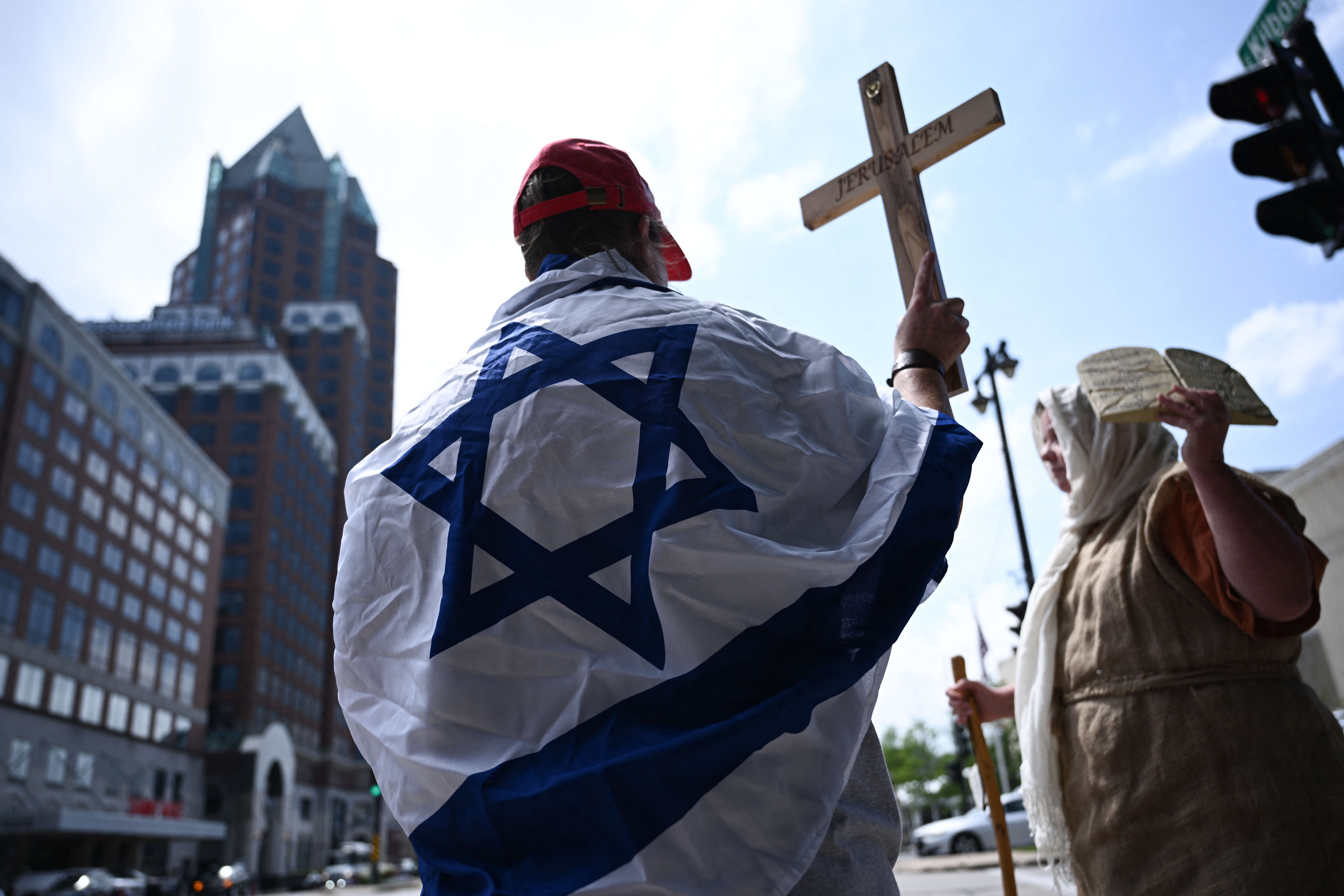 Outside the RNC, a Christian woman wears an Israeli flag while holding a cross.