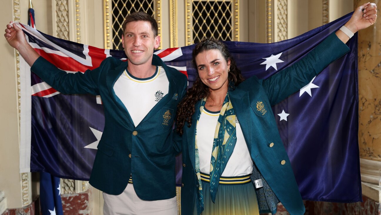 Eddie Ockenden and Jessica Fox pose with the Australian flag after being named flag bearers ahead of the Paris 2024 Olympic Games, July 24, 2024, in Paris. (Richard Pelham/Getty Images)