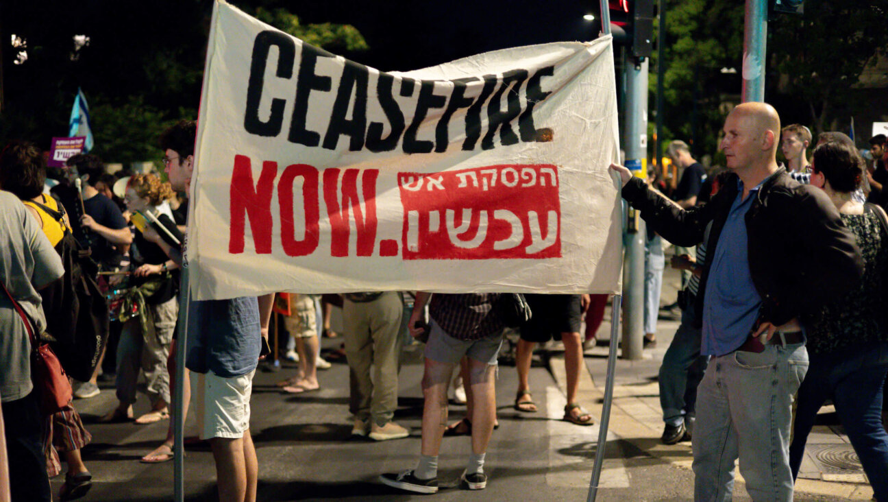 A protester holds a sign reading "Ceasefire Now" at a July 7 anti-government protest in Israel calling for immediate hostage deal. 