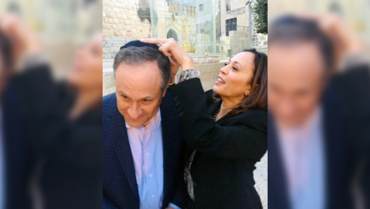 Kamala Harris affixes a kippah to the head of her husband, Douglas Emhoff, as they visit the Western Wall, Jerusalem, November 2017. (Halie Soifer)