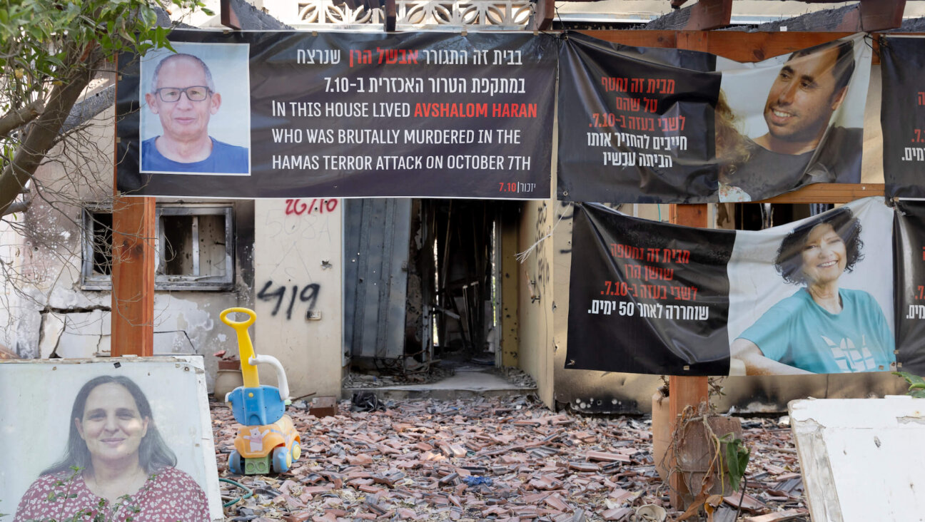 Signs with photos of people who were kidnapped or killed on Oct. 7 hang on a house in Kibbutz Be'eri that was damaged during Hamas' deadly Oct. 7 attack on southern Israel.