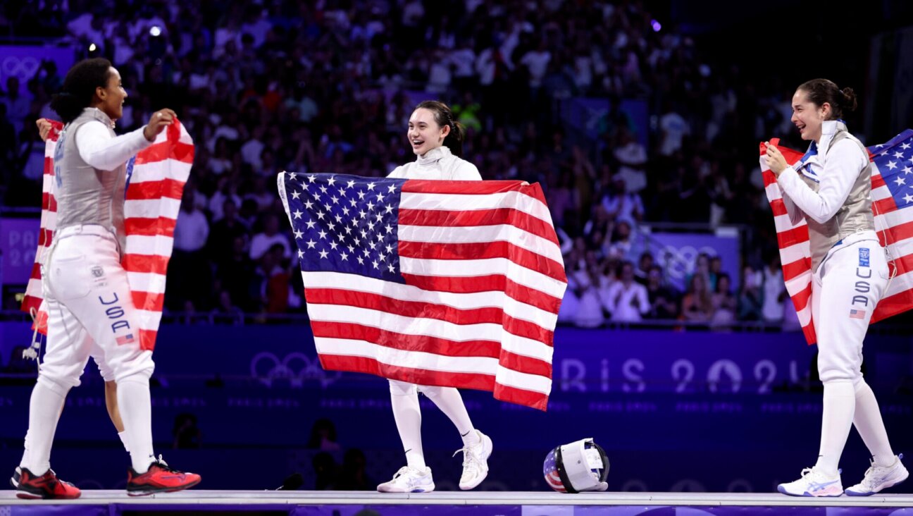 Lauren Scruggs, Maia Weintraub and Jackie Dubrovich of Team United States celebrate winning against Italy during the fencing women’s foil team gold medal match at the Paris Olympics, Aug. 1, 2024.(Clive Brunskill/Getty Images)