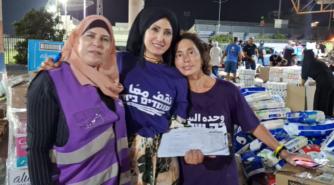 The author, at right, and other Standing Together volunteers collect humanitarian aid for civilians in Gaza at Umm al-Fahem, a mostly Arab Israeli city in the Haifa district, Aug. 11, 2024. (Jacob Ner-David)