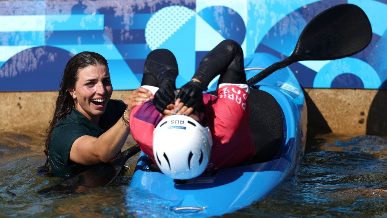 Noemie Fox, right, celebrates with Jessica Fox after winning gold in the canoe slalom women's kayak cross final at the 2024 Paris Olympics, Aug. 5, 2024, in Paris. (Alex Davidson/Getty Images)
