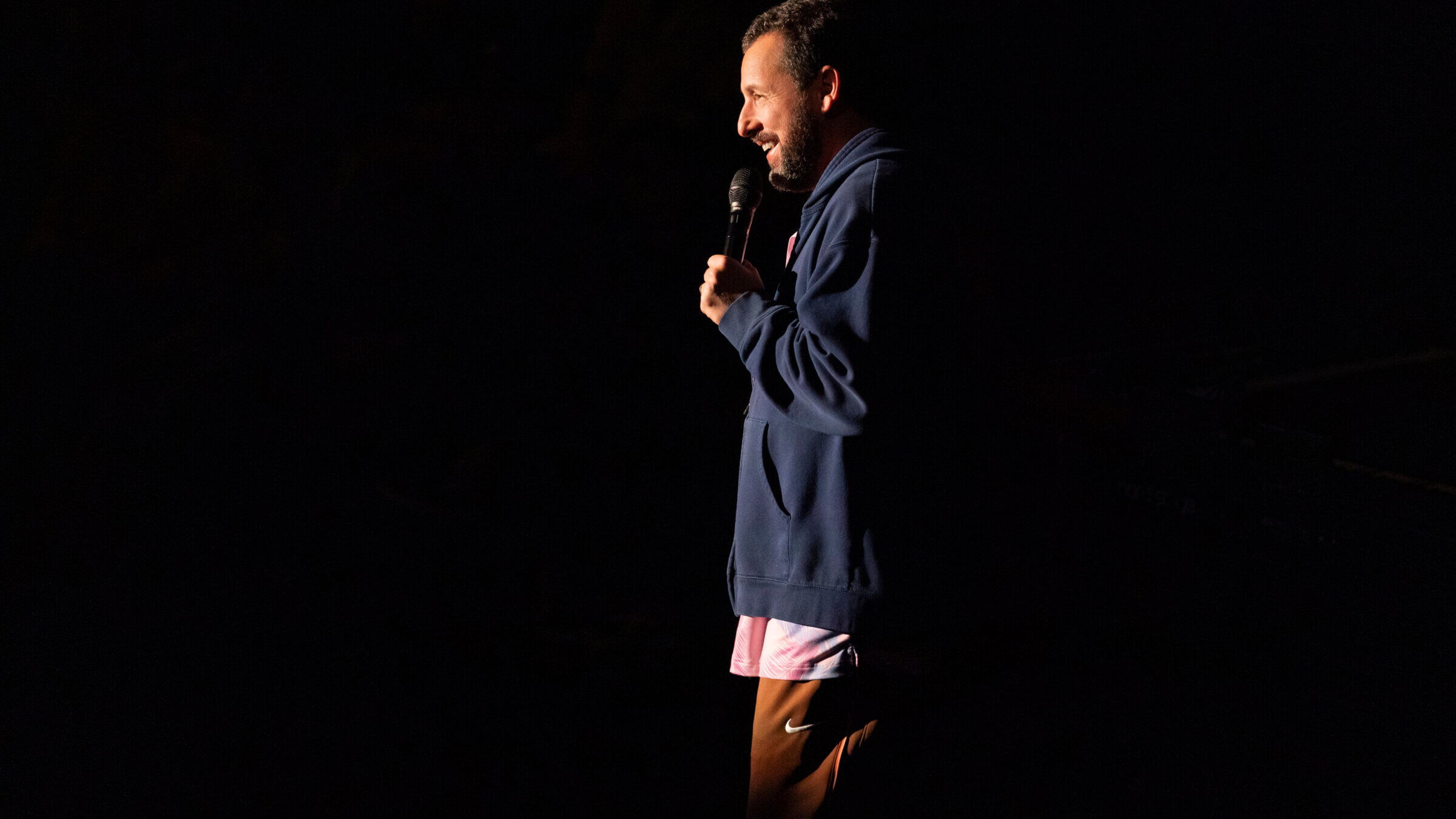 Adam Sandler in his usual sweats onstage.