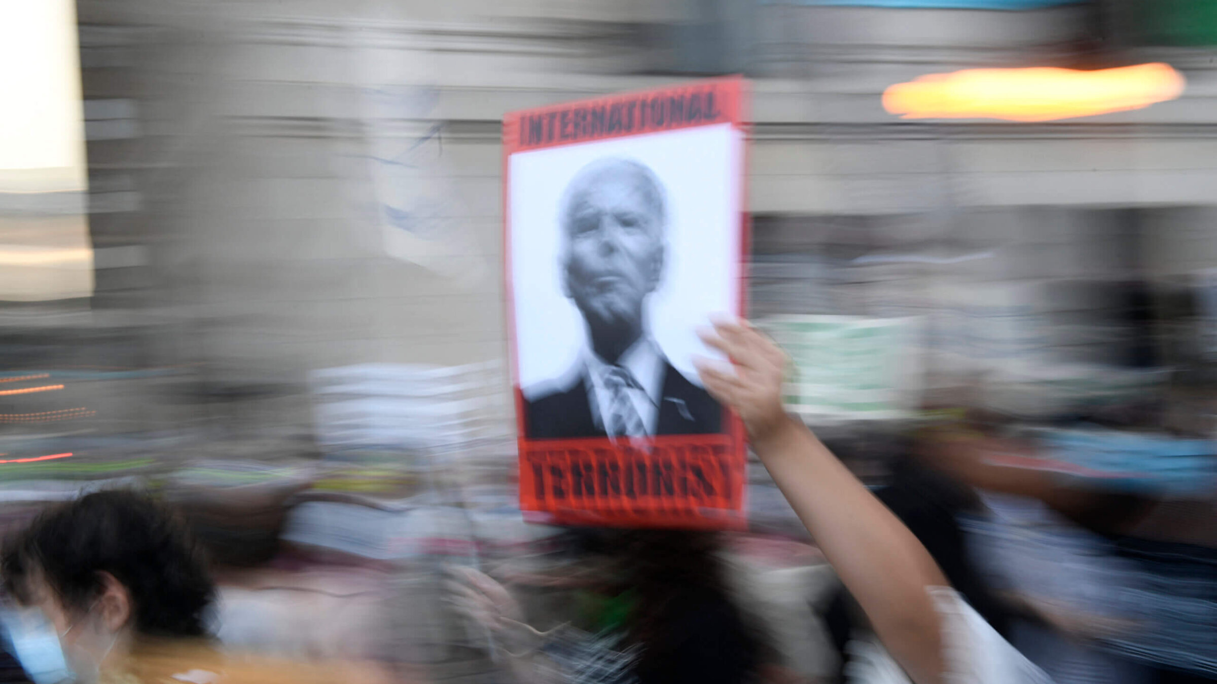 A demonstrator holds a sign that reads "International terrorism" with a portrait of US President Joe Biden during a protest rally demanding reproductive justice, defending the rights of trans and queer people, and calling for a ceasefire in Gaza on the eve of the Democratic National Convention on August 18 in Chicago, Illinois. 