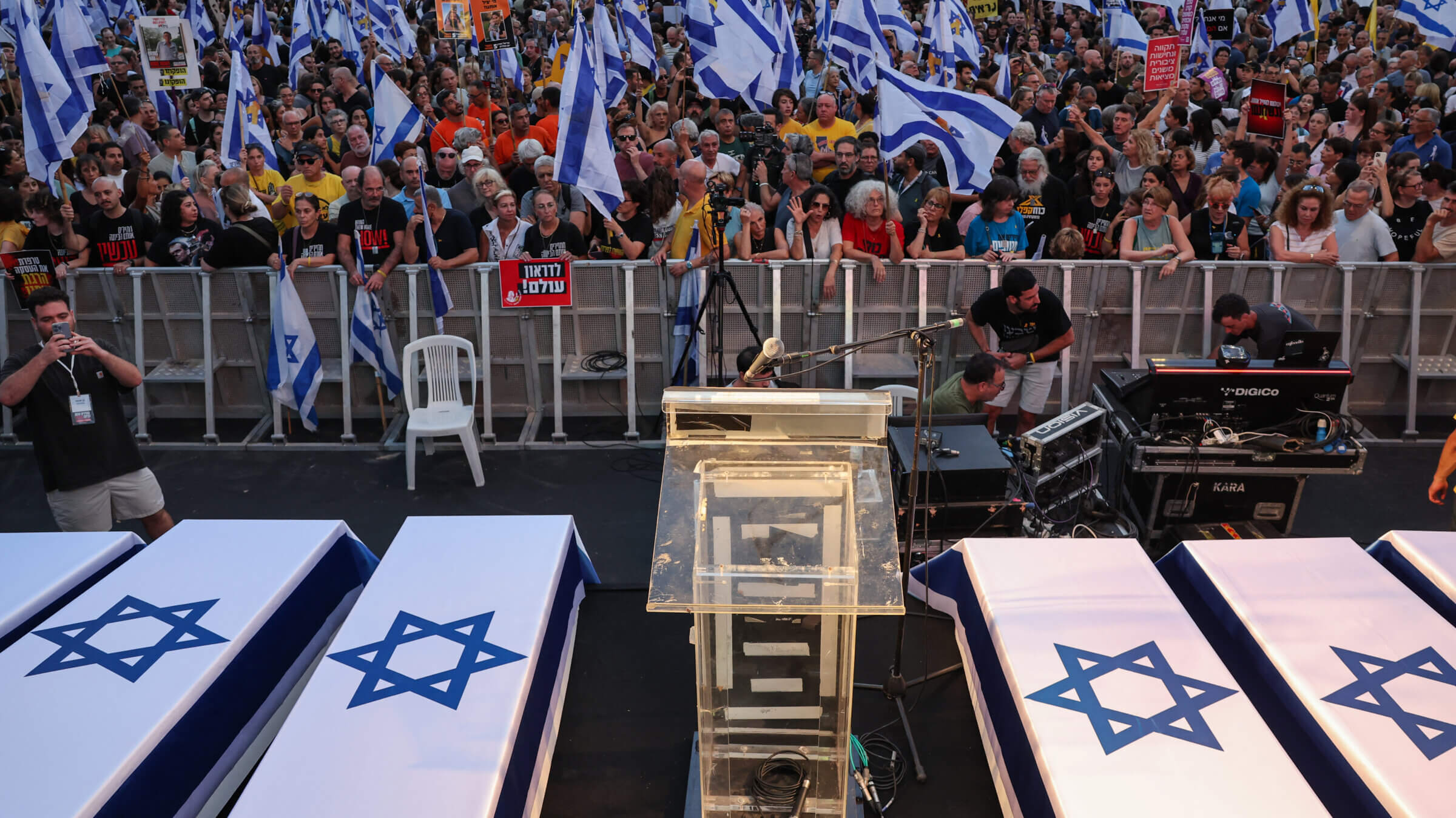 Protesters lift flags and placards next to symbolic coffins representing six Israeli hostages whose bodies were recovered from the Gaza Strip, during an anti-government rally calling for the release of the captives held by Palestinian militants in Gaza since October, in Tel Aviv on Sept. 1, 2024.