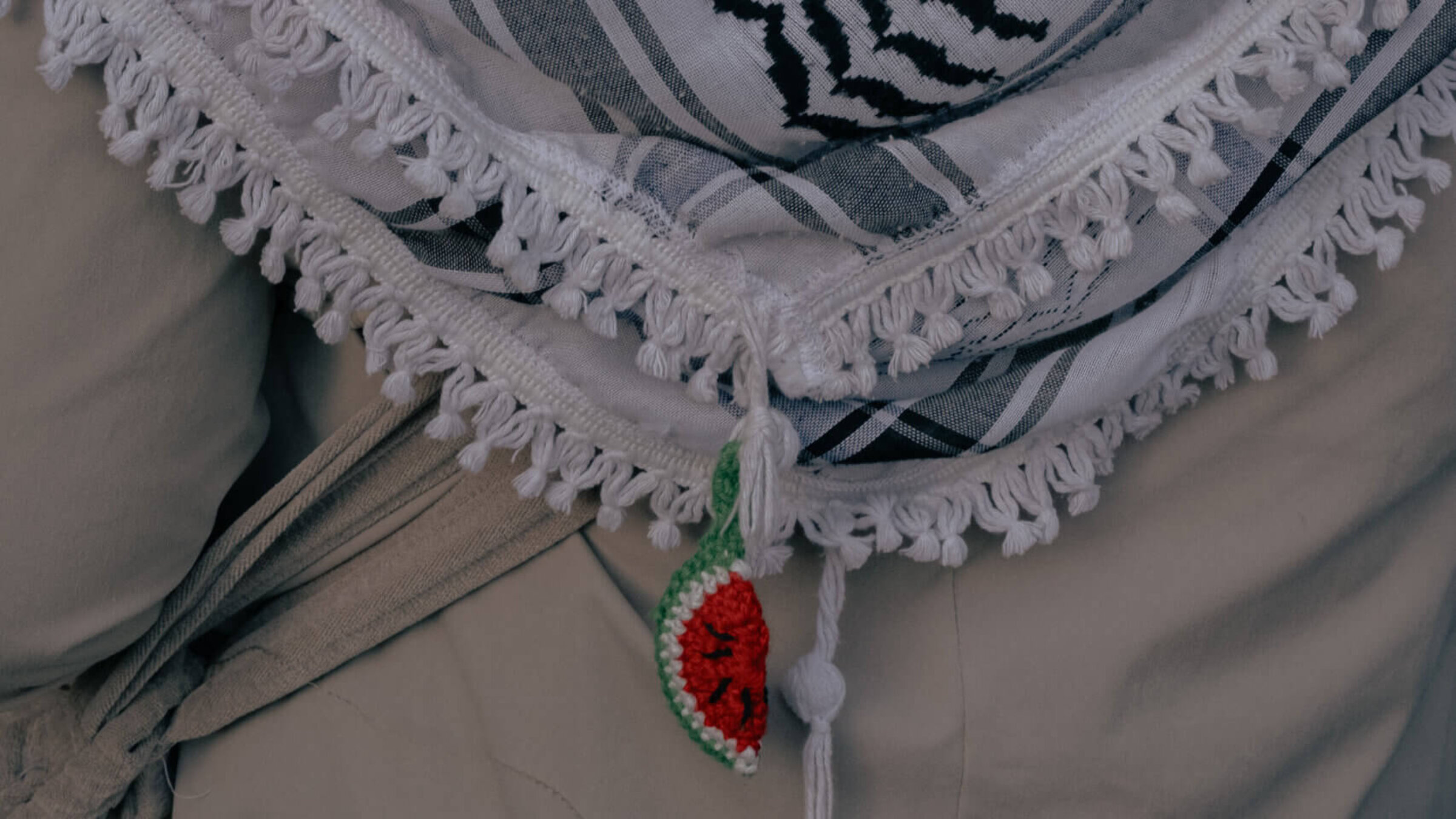 A crocheted watermelon hung from a Palestinian keffiyeh seen at a demonstration in solidarity with Palestine.