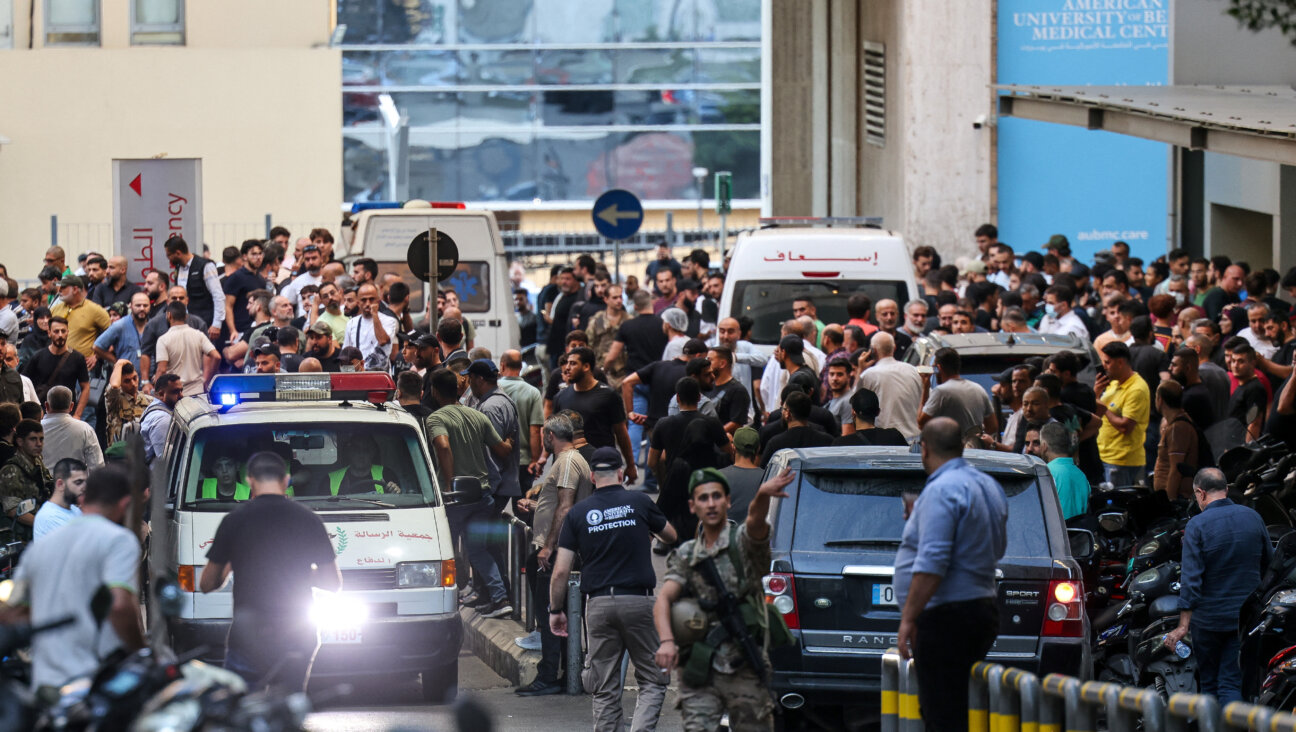 Ambulances are surrounded by people at the entrance of the American University of Beirut Medical Center after paging devices exploded in Lebanon. 