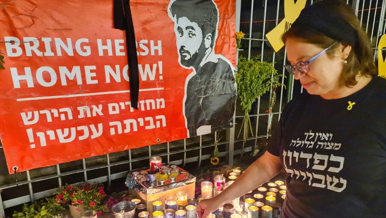 Shira Ben-Sasson, a founder of the Hakhel synagogue in Jerusalem, lights a candle in memory of Hersh Goldberg-Polin, Sept. 1, 2024. (Deborah Danan)