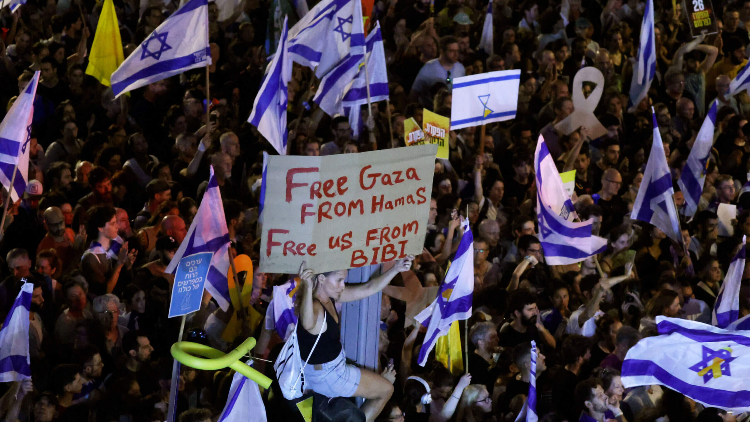 A protester holds up a sign as they join a crowd gathered to demand a deal to bring home hostages from Gaza, Sept. 1, Tel Aviv, Israel. 