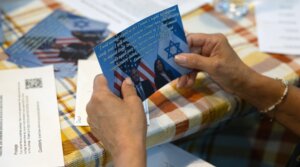 Ilene Miller holds a postcard that she has volunteered to send out to Jewish voters on behalf of the Democratic Committee of Lower Merion and Narberth in Wynnewood, Pennsylvania, Sept. 17, 2024. (Rachel Wisniewski/For the Washington Post/Getty Images)