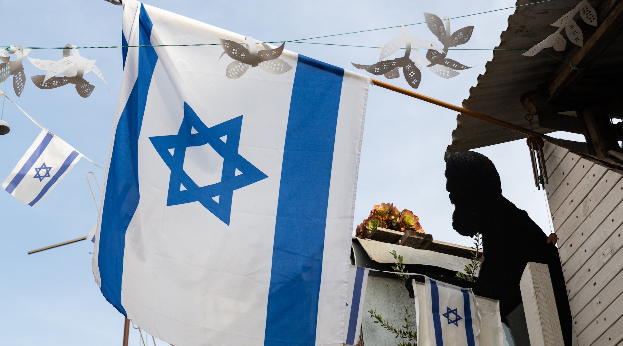 A silhouette of Theodor Herzl, the founder of modern Zionism, is displayed near a flag of the state of Israel on a building in Jerusalem. (Yehoshua Halevi/Getty Images)