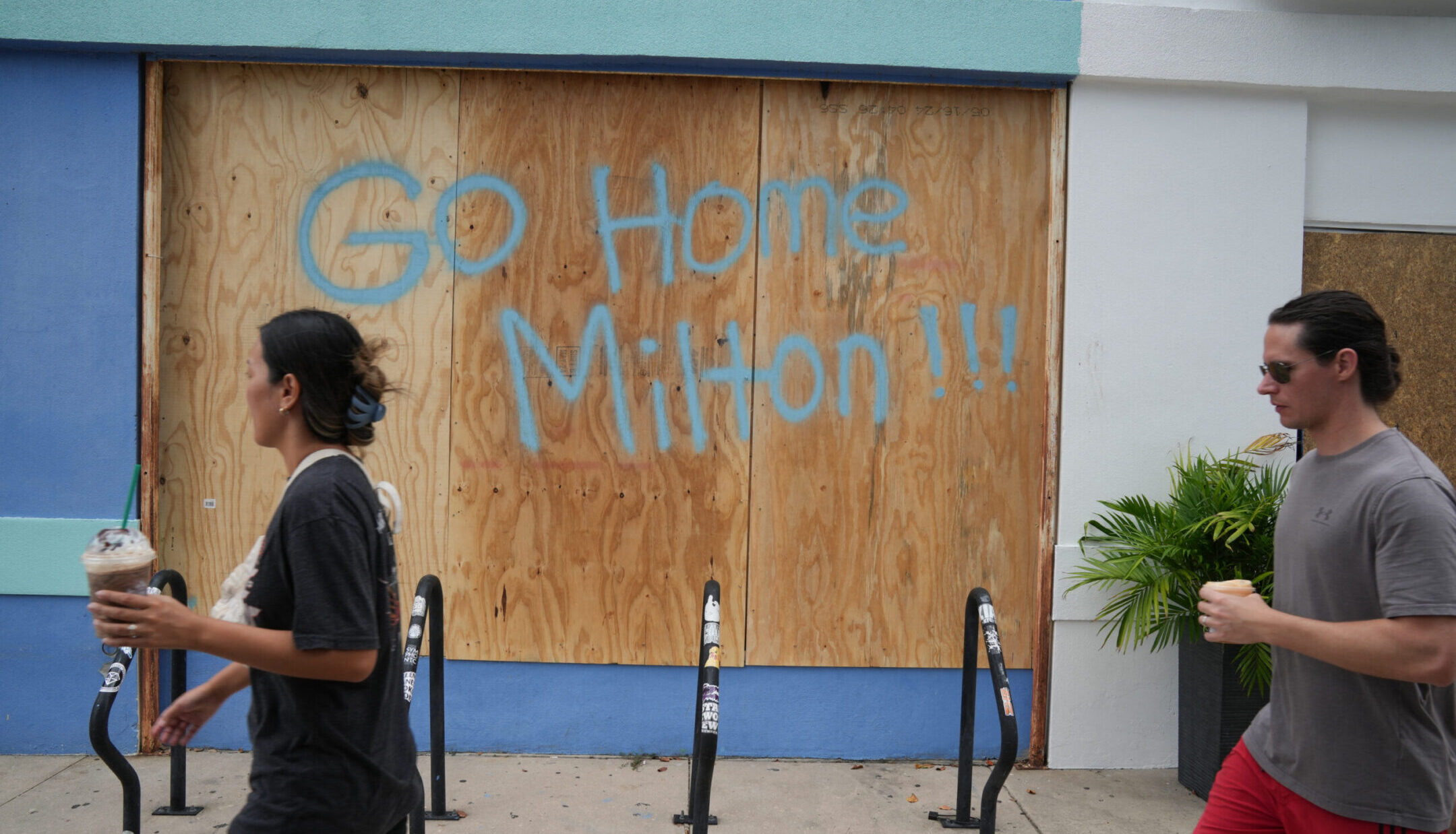 People walk past boarded up storefronts in Tampa, Florida, ahead of Hurricane Milton’s expected landfall, Oct. 8, 2024. (Bryan Smith/AFP via Getty Images)