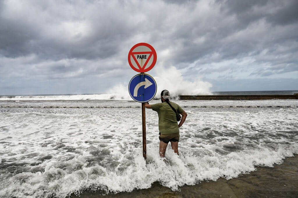 A man looks at waves crashing against the promenade in Havana due to the passage of Hurricane Milton Oct. 9.