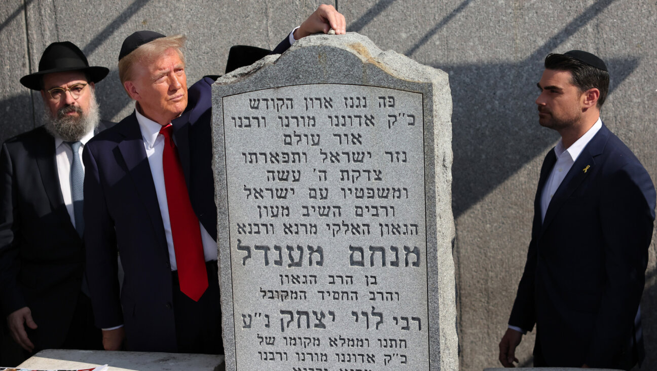 Republican presidential nominee Donald Trump, places a rock on the gravestone of Rabbi Menachem Mendel Schneerson as Ben Shapiro watches at Ohel Chabad Lubavitch on October 7, 2024 in New York City. (Michael M. Santiago/Getty Images)