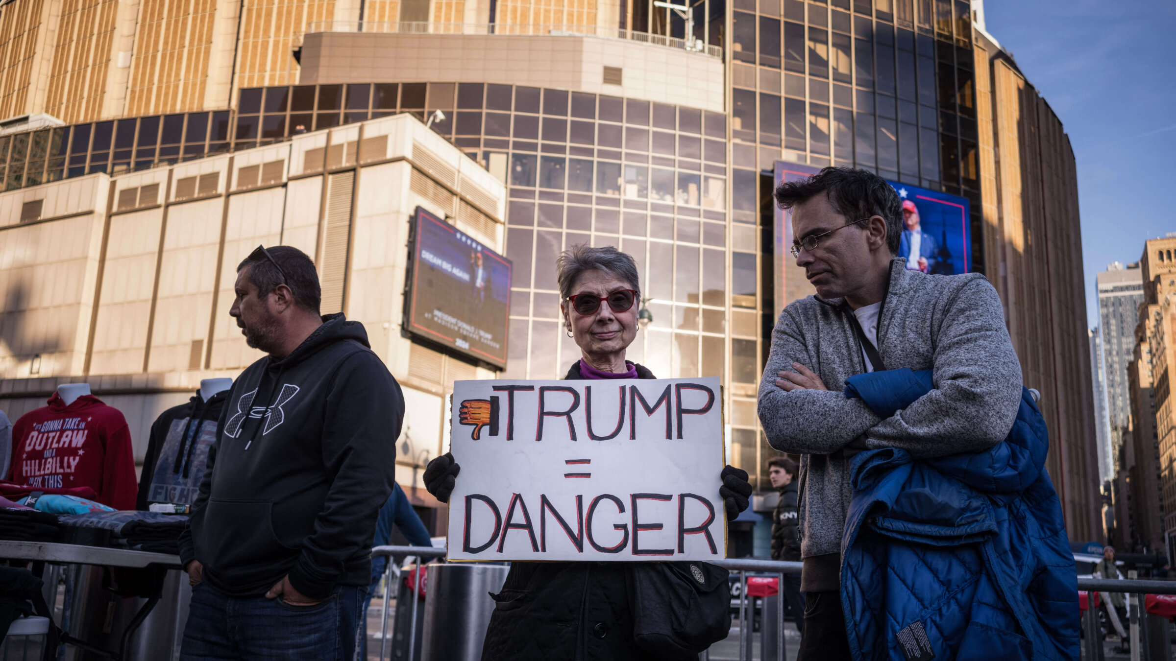 A demonstrator holds a "Trump = Danger" sign during a "Resist Facism" protest as former US President and Republican presidential candidate Donald Trump holds a campaign rally at Madison Square Garden in New York, October 27, 2024.