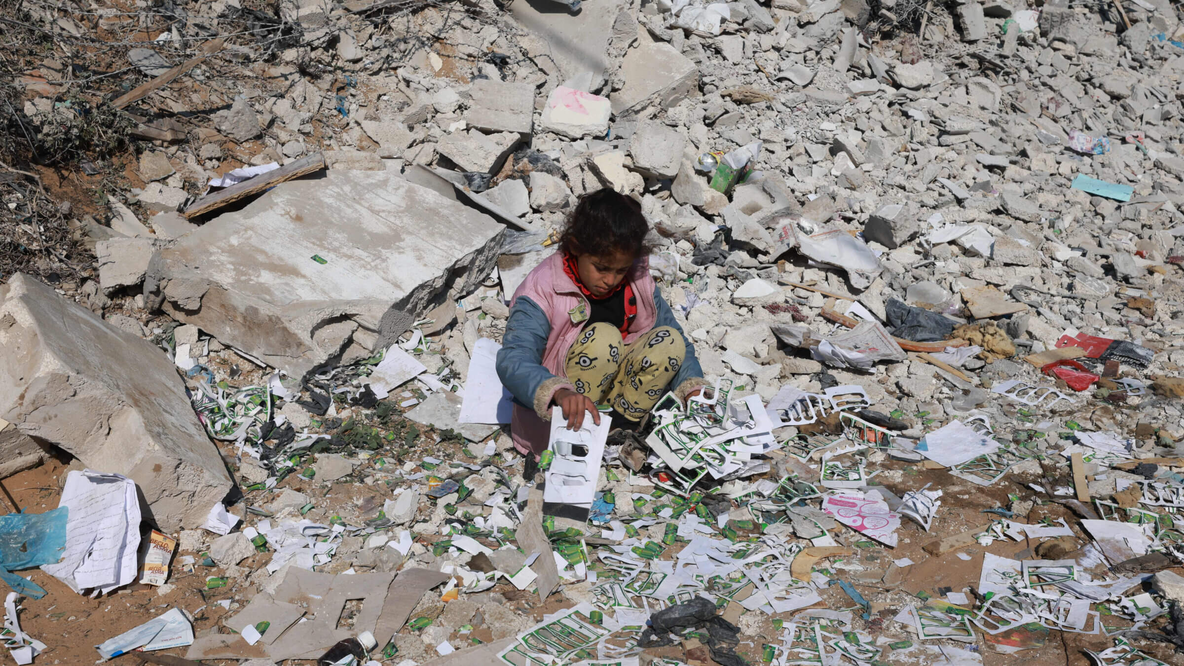 TOPSHOT - A Palestinian girl looks for salvageable items amid the destruction  on the southern outskirts of Khan Yunis in the war-battered Gaza Strip on January 16, 2024, amid continuing fighting between Israel and the Palestinian militant group Hamas.