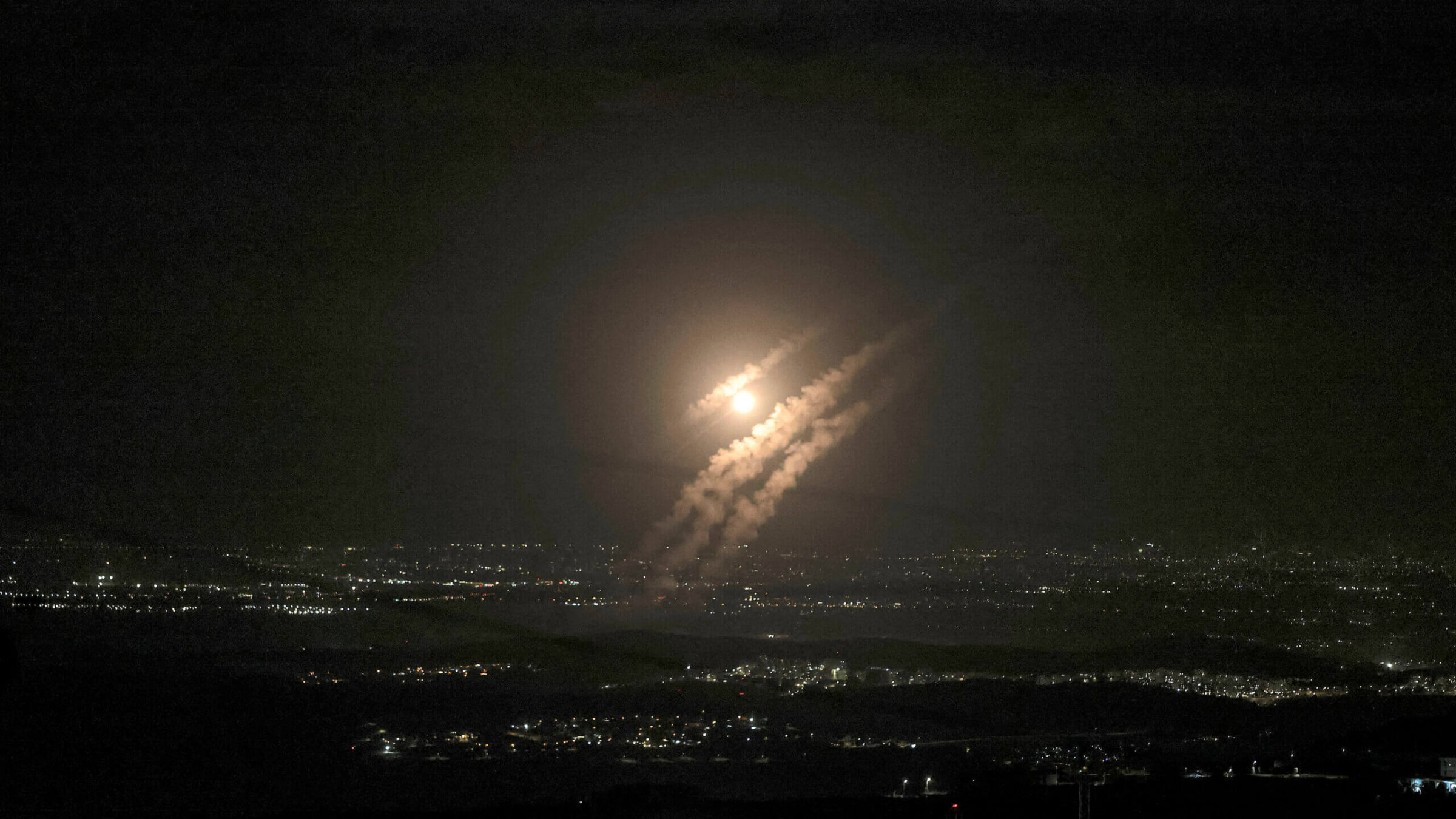 Projectiles from Iran's Tuesday airstrike on Israel fall above the city of Ashdod, seen from Hebron in the West Bank. 