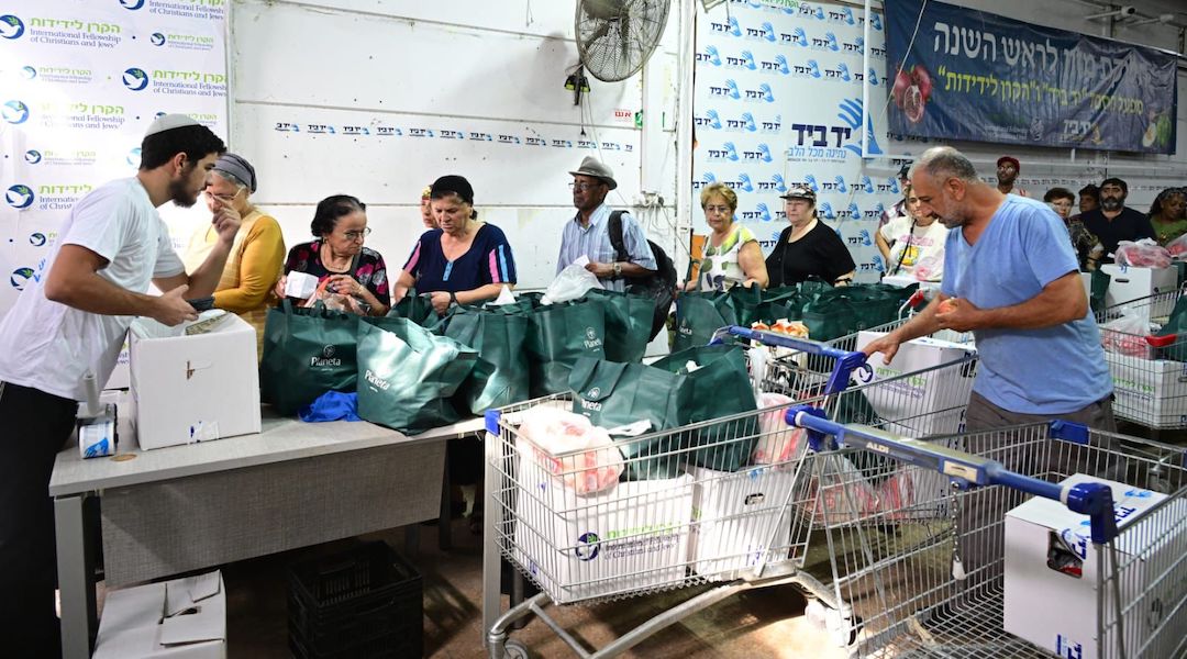 Volunteers distribute food at the facilities of social services nonprofit Yad Ba’yad in Lod, where 500 people received food packages in preparation for the upcoming holidays. (Yossi Zeliger)