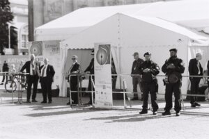 Police and security guards standing outside of a tent for a Torah commemoration event.