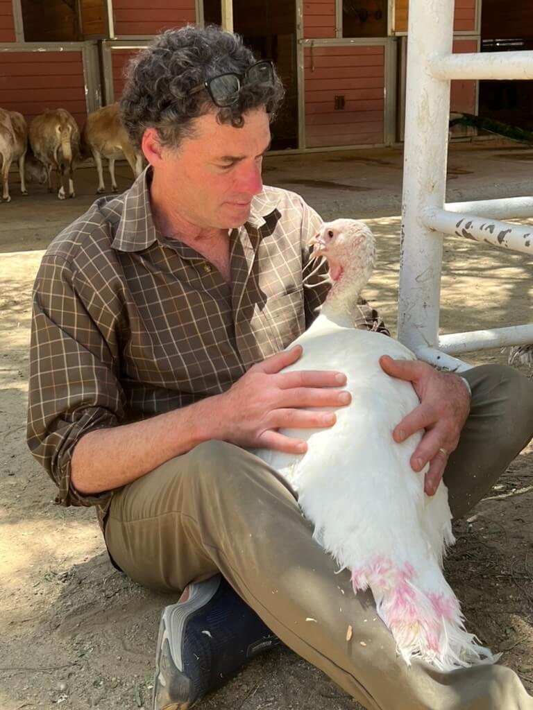 Rob Eshman hugging Justice the turkey at Gentle Barn in Santa Clarita, Calif.