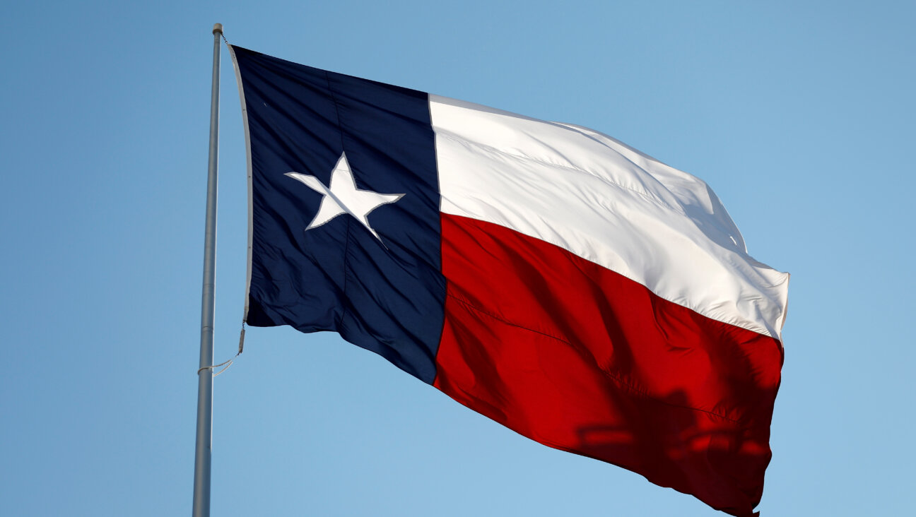 The Texas state flag flies in Austin, TX.