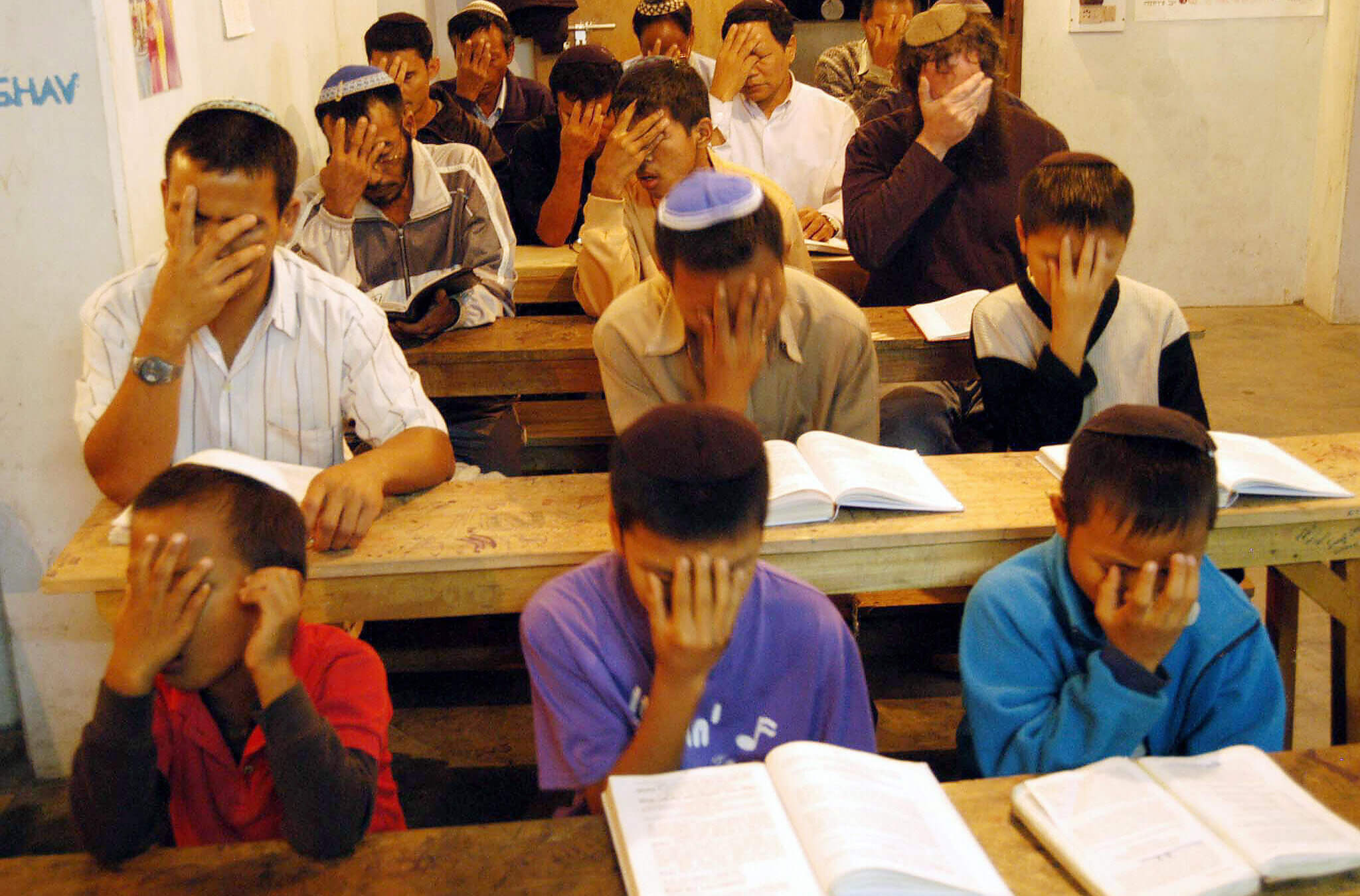 Jews place their hands to their faces in prayer.