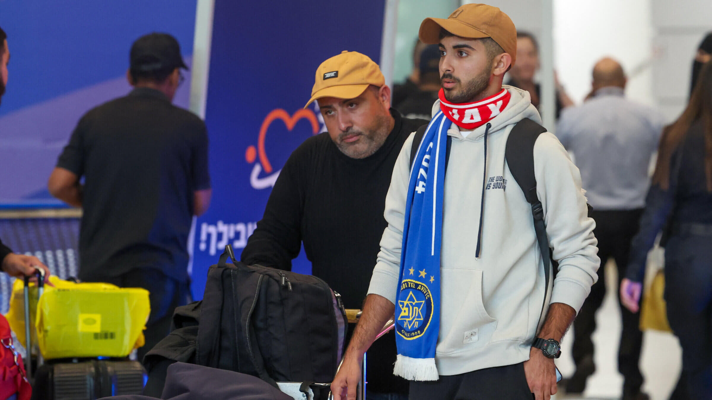 A fan of the Israeli Maccabi soccer team walks through David Ben-Gurion airport after Israeli officials evacuated Israelis from Amsterdam Thursday night.