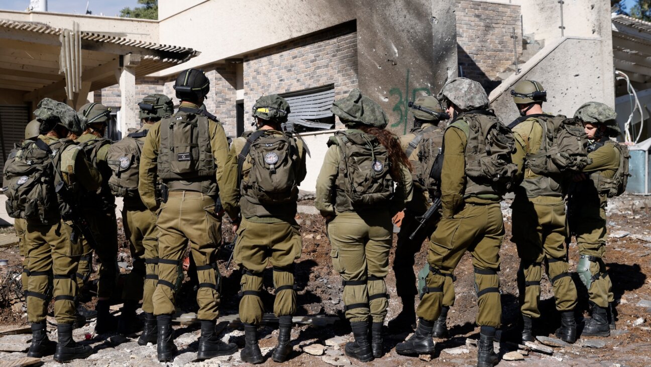 Israeli army forces stand outside a house that was hit by rockets fired by Hezbollah from Lebanon in the northern Israeli border town of Kiryat Shmona on Nov. 26, 2024. (Jalaa Marey/AFP via Getty Images)