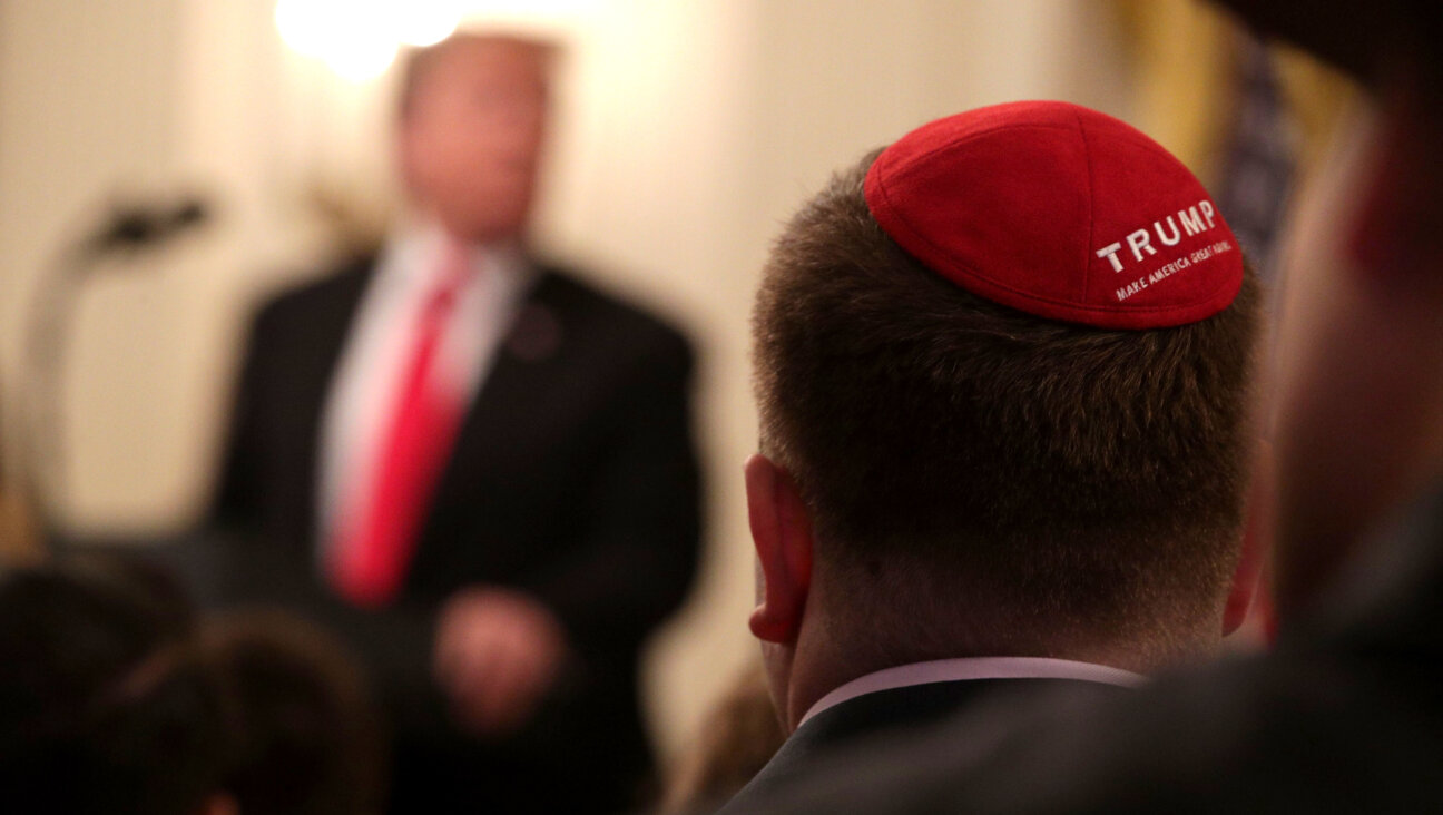 A man with a yarmulke listens to U.S. President Donald Trump.