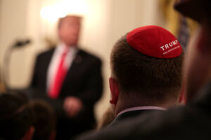 A man with a yarmulke listens to U.S. President Donald Trump.