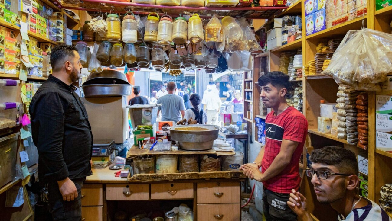 A shopkeeper helps a customer at the Azra Alyahoodi (Azra the Jew) market also known as the “Jewish market,” in the city of Qamishli in northeastern Syria, on July 27, 2023. (Photo by Delil Souleiman/AFP via Getty Images)