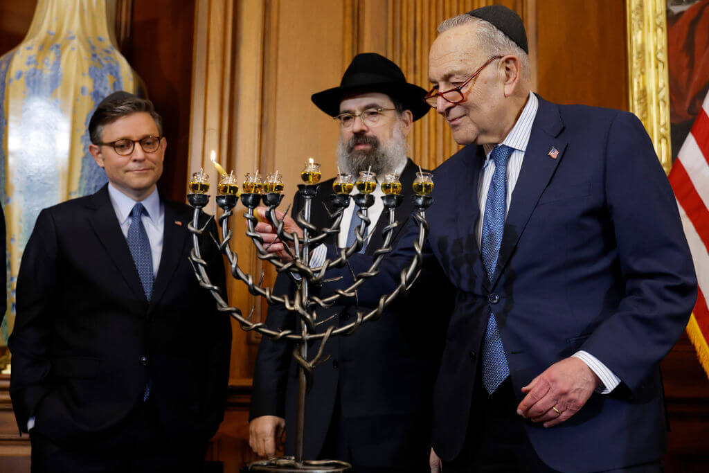 Left to right: Speaker of the House Mike Johnson, Rabbi Levi Shemtov and Senate Majority Leader Chuck Schumer light a menorah during a Hanukkah reception at the U.S. Capitol Dec. 17.