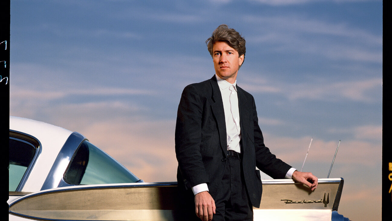 David Lynch stands outdoors in front of Packard vehicle in Los Angeles in 1986.