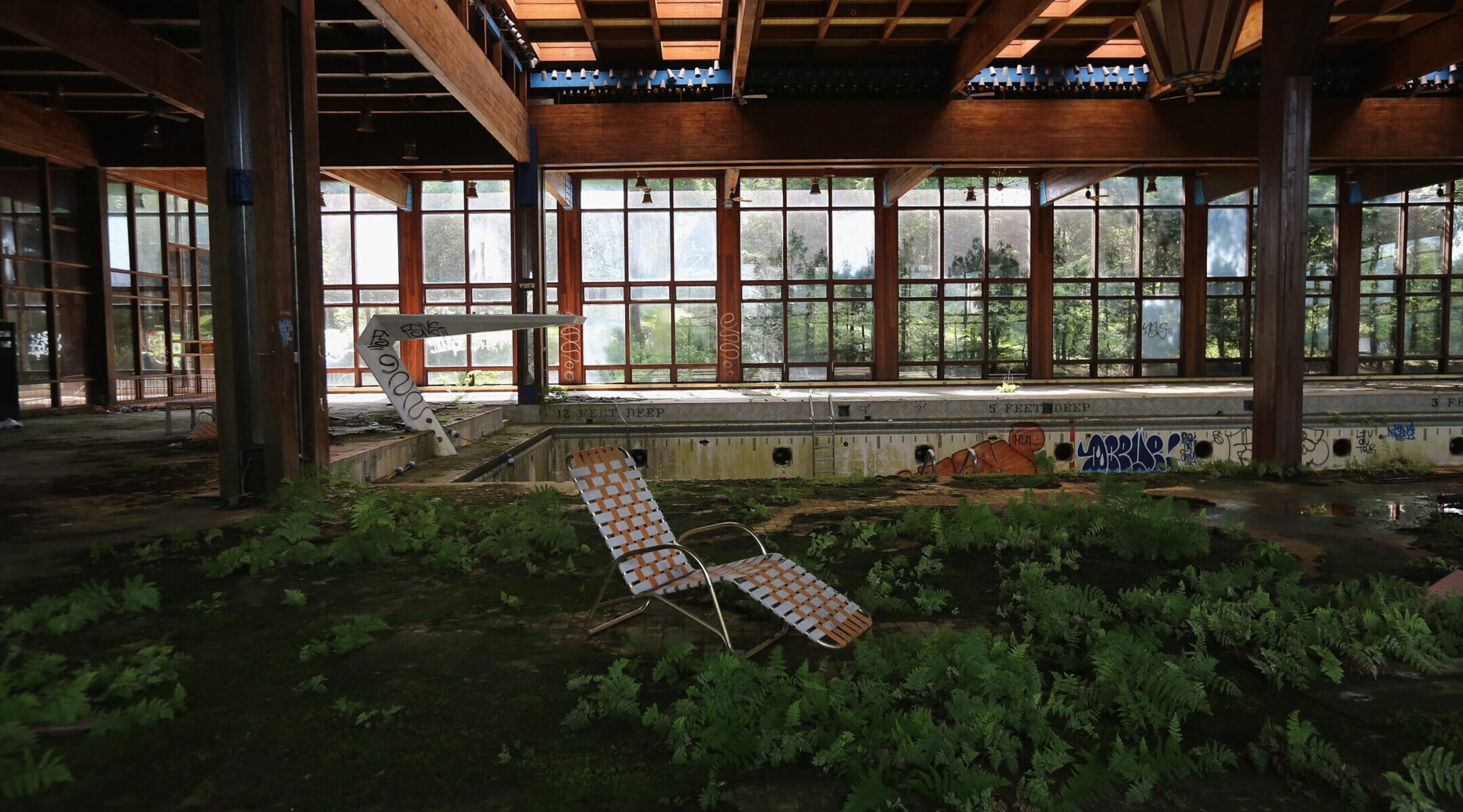 A lawn chair sits as nature takes over the indoor pool area of Grossinger’s Catskill Resort Hotel on July 5, 2012 in Liberty, New York. The hotel, closed since 1986, is one of many Borscht Belt hotels that shut down over the years. (John Moore/Getty Images)