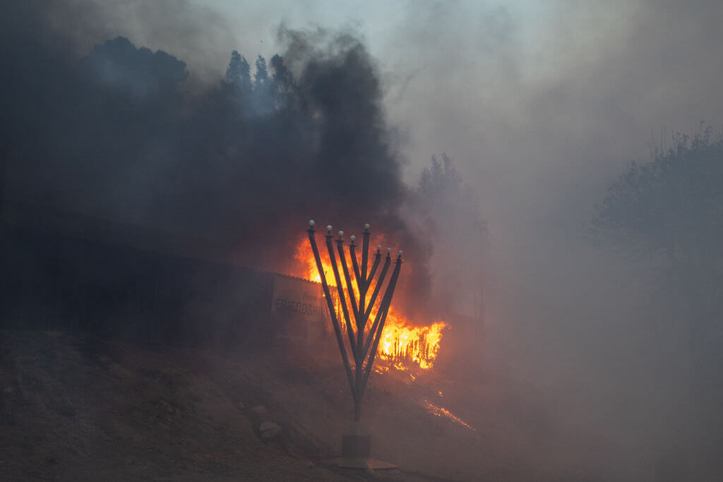 Flames from the Palisades Fire burn in front of the Jewish Temple Chabah of Pacific Palisades in Los Angeles. 