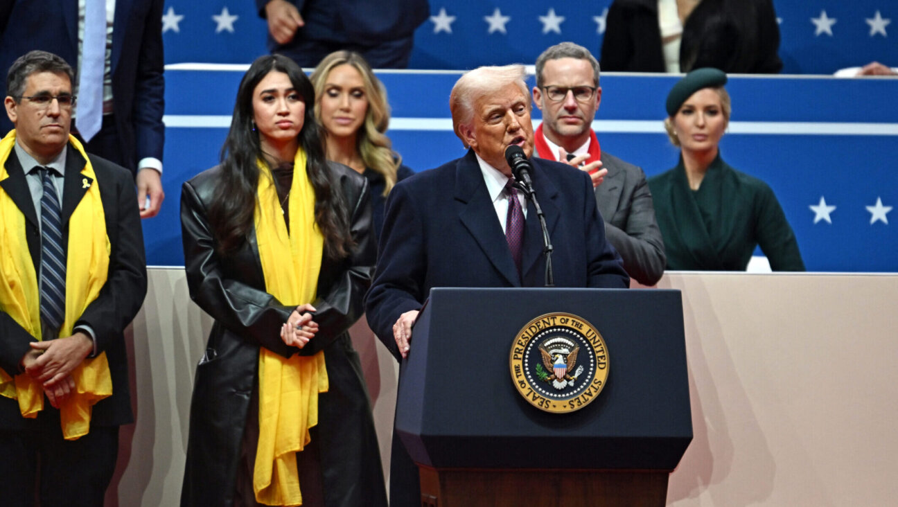 President Donald Trump speaks during an inaugural rally on Jan. 20, 2025, with Noa Argamani, an Israeli former hostage, standing behind him. 