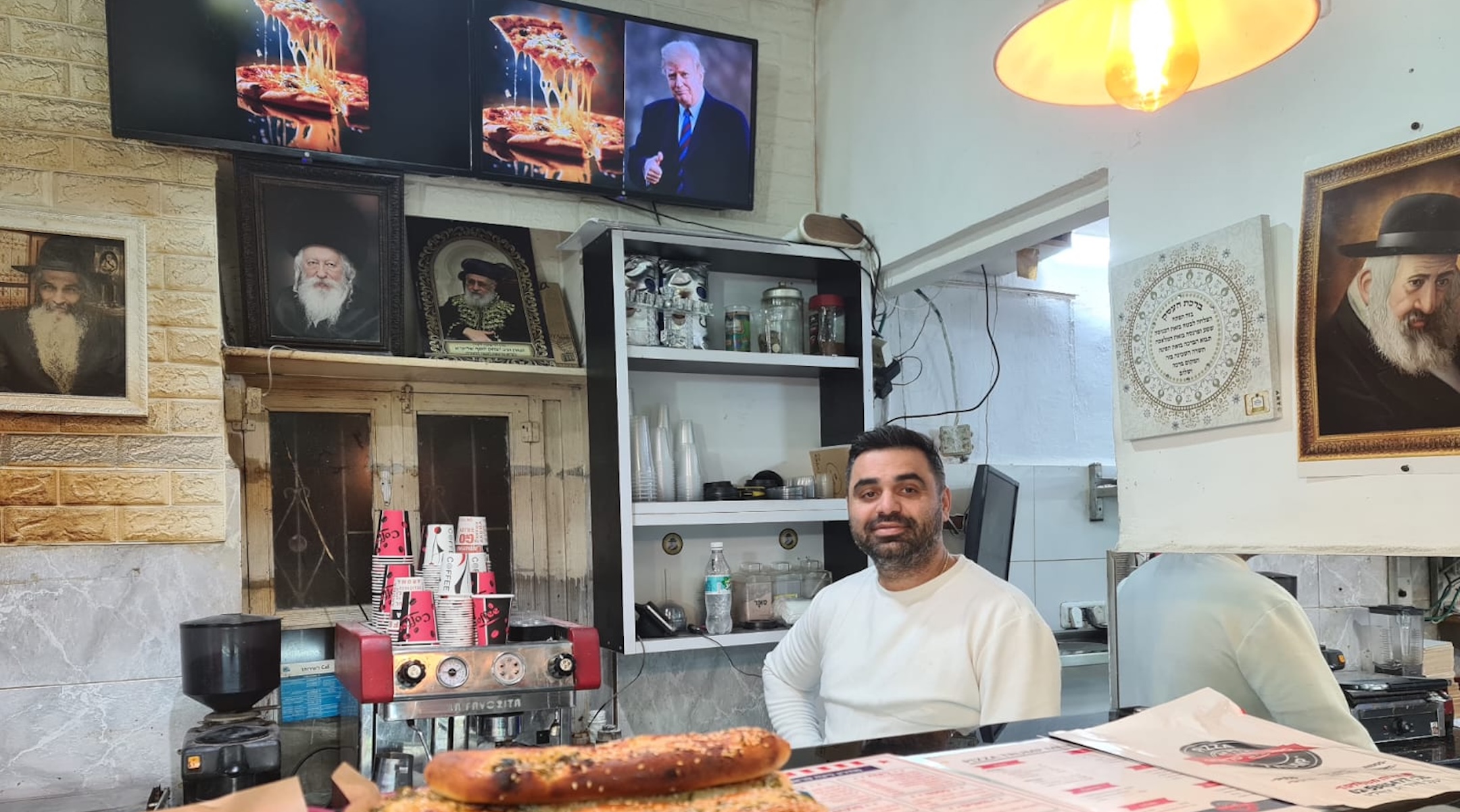 Yitzchak Babayoff, the owner of Pizza Trump in Jerusalem, poses in his shop on Inauguration Day, Jan. 20, 2025. (Deborah Danan)