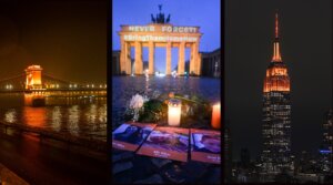 L-R: Budapest’s Chain Bridge; Berlin’s Brandenburg Gate; and New York City’s Empire State Building are illuminated in orange to honor the slain Bibas family, Feb. 26, 2025. (Courtesy Kidma; Sebastian Gollnow/picture alliance via Getty Images; Craig T Fruchtman/Getty Images)