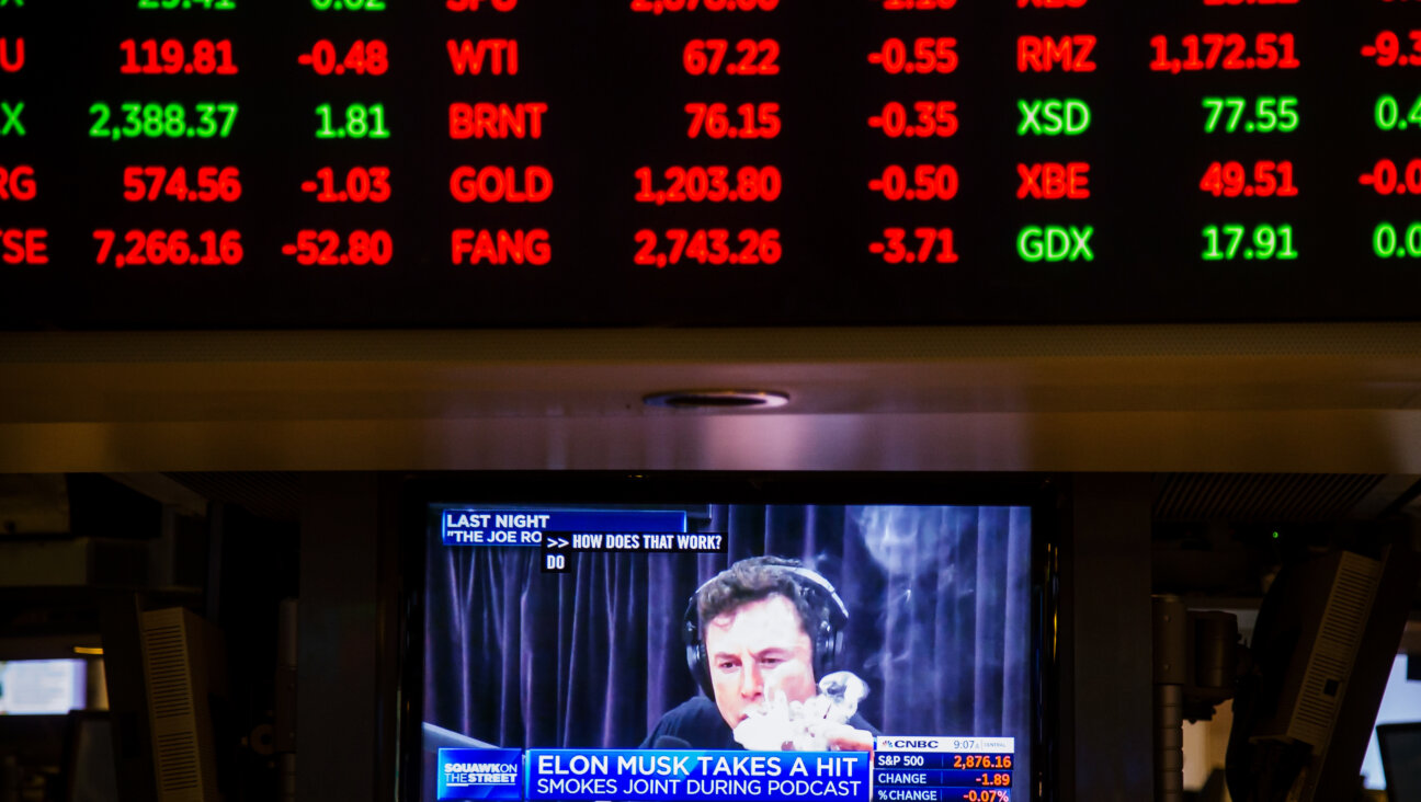 Elon Musk is seen on a television on the floor of the New York Stock Exchange in 2018.