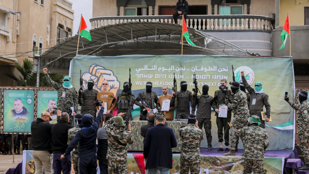 Israeli hostages stand on stage flanked by Hamas militants during the official handover in Gaza, Gaza Strip, on February 8, 2025. (Youssef Alzanoun / Middle East Images / Middle East Images via AFP)