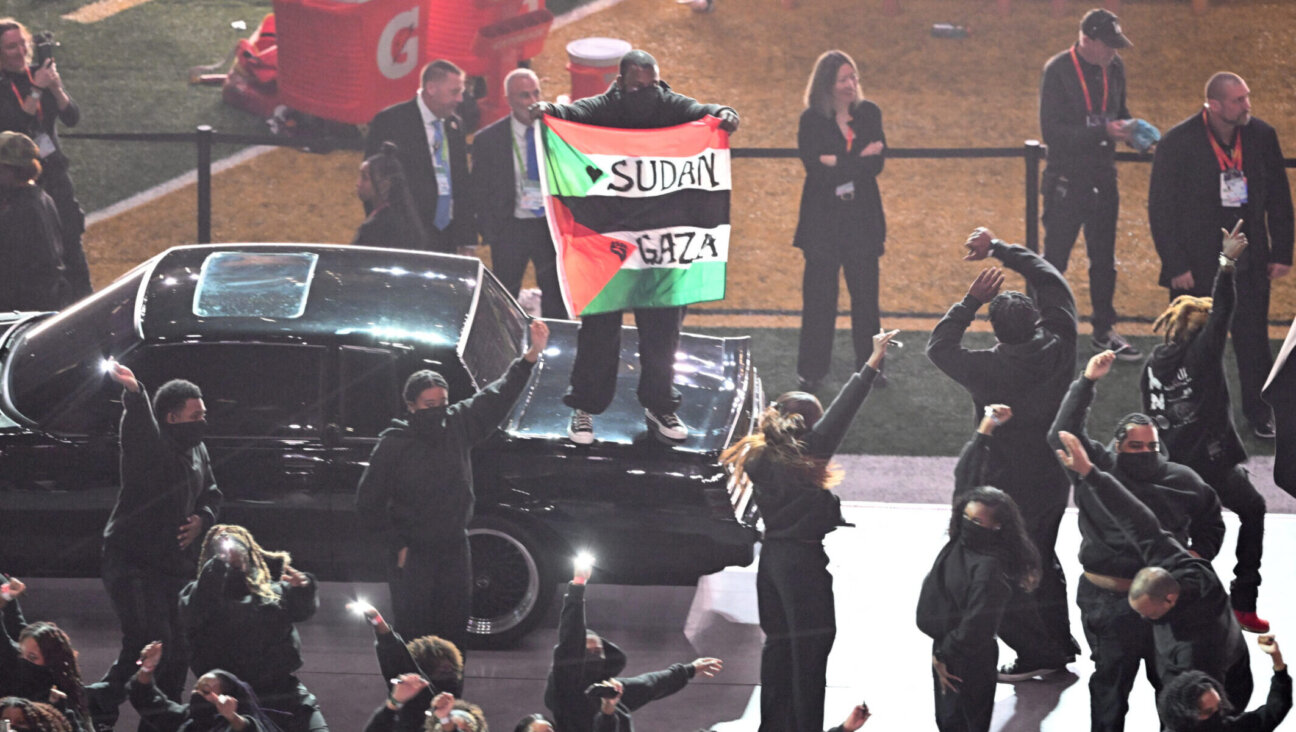 A protester holds a Sudan/Palestinian flag with the words “Gaza” and “Sudan” as US rapper Kendrick Lamar performs during thee Super Bowl LIX halftime show, Feb. 9, 2025. (Chandan Khanna/AFP via Getty Images)