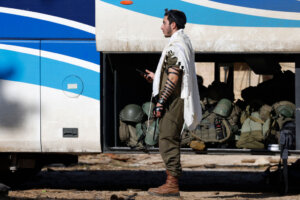 An Israeli soldier prays in front of a bus at the border with Lebanon on February 18, after troops left south Lebanon.