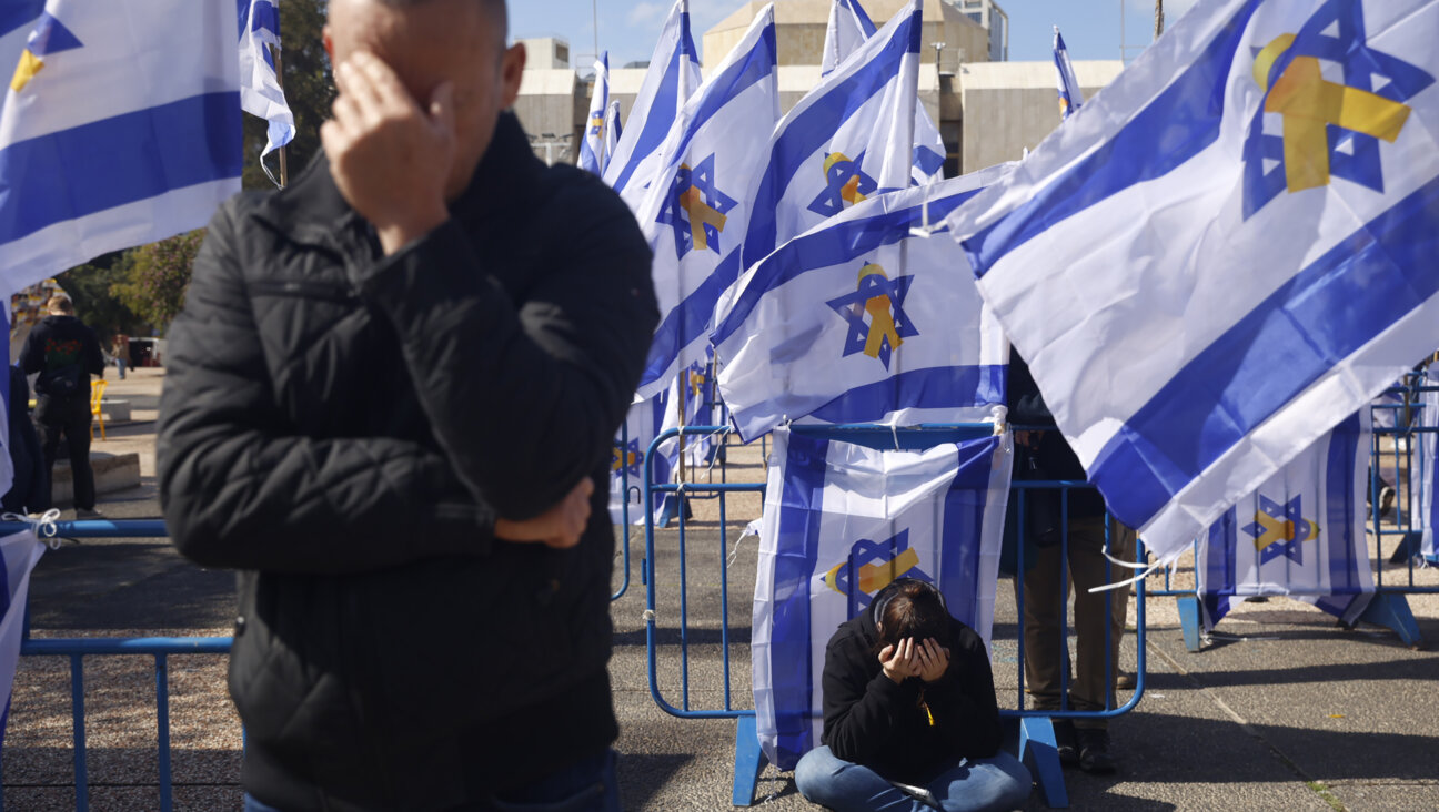 People react among Israeli flags in Hostage Square prior to the handover of four bodies taken by Hamas.